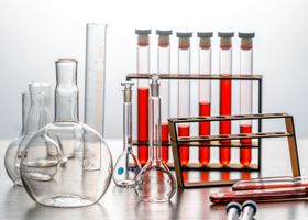 Close-up of various lab glassware with red liquids, ideal for scientific or educational use.